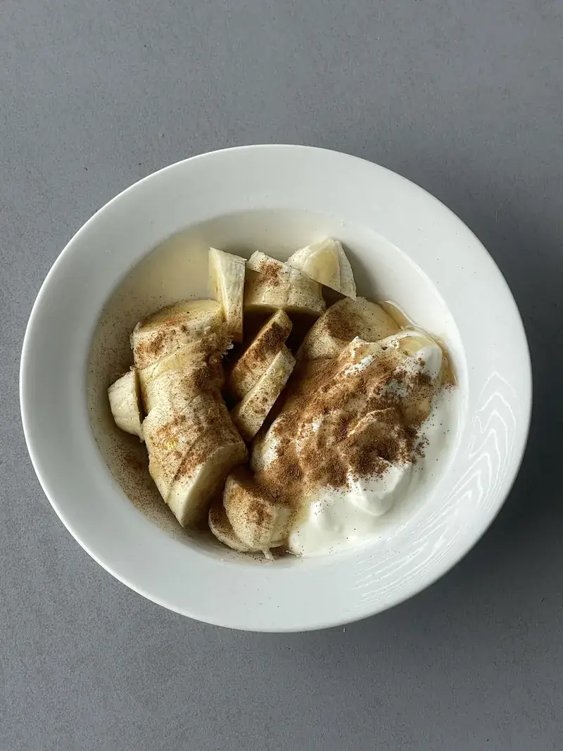 Sliced banana over Greek yoghurt with honey and cinnamon
