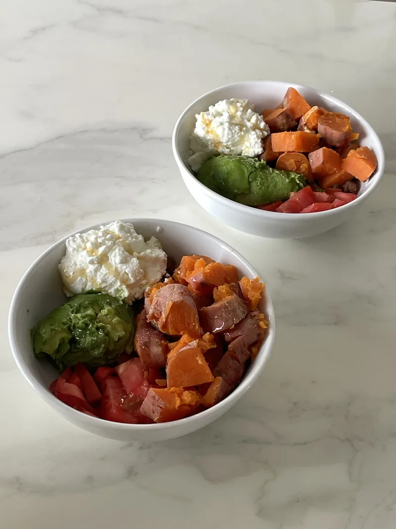 Two bowls of lean beef mince with sweet potato, avocado, tomato and cottage cheese