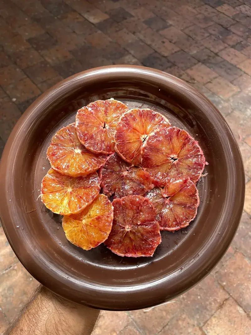 Sliced blood oranges on a brown plate