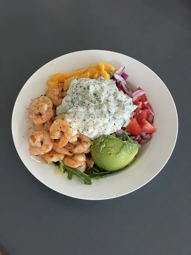 Paprika prawns with mango, tomato, red onion, avocado and rocket under a scoop of tzatziki