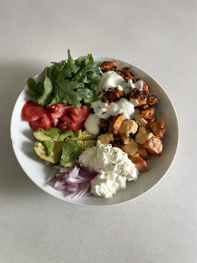 Charred paprika chicken bowl with sweet potato, rocket, tomato, avocado, red onion, cottage cheese and yoghurt drizzle