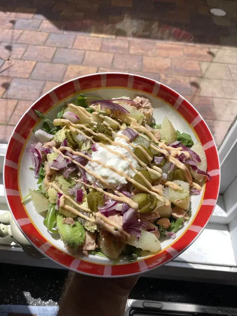 Tuna and potato salad with rocket, avocado, pickles, red onion, cottage cheese and a sriracha mayo drizzle